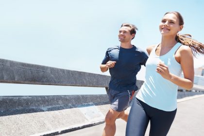 Shot of two young runners training together on the road